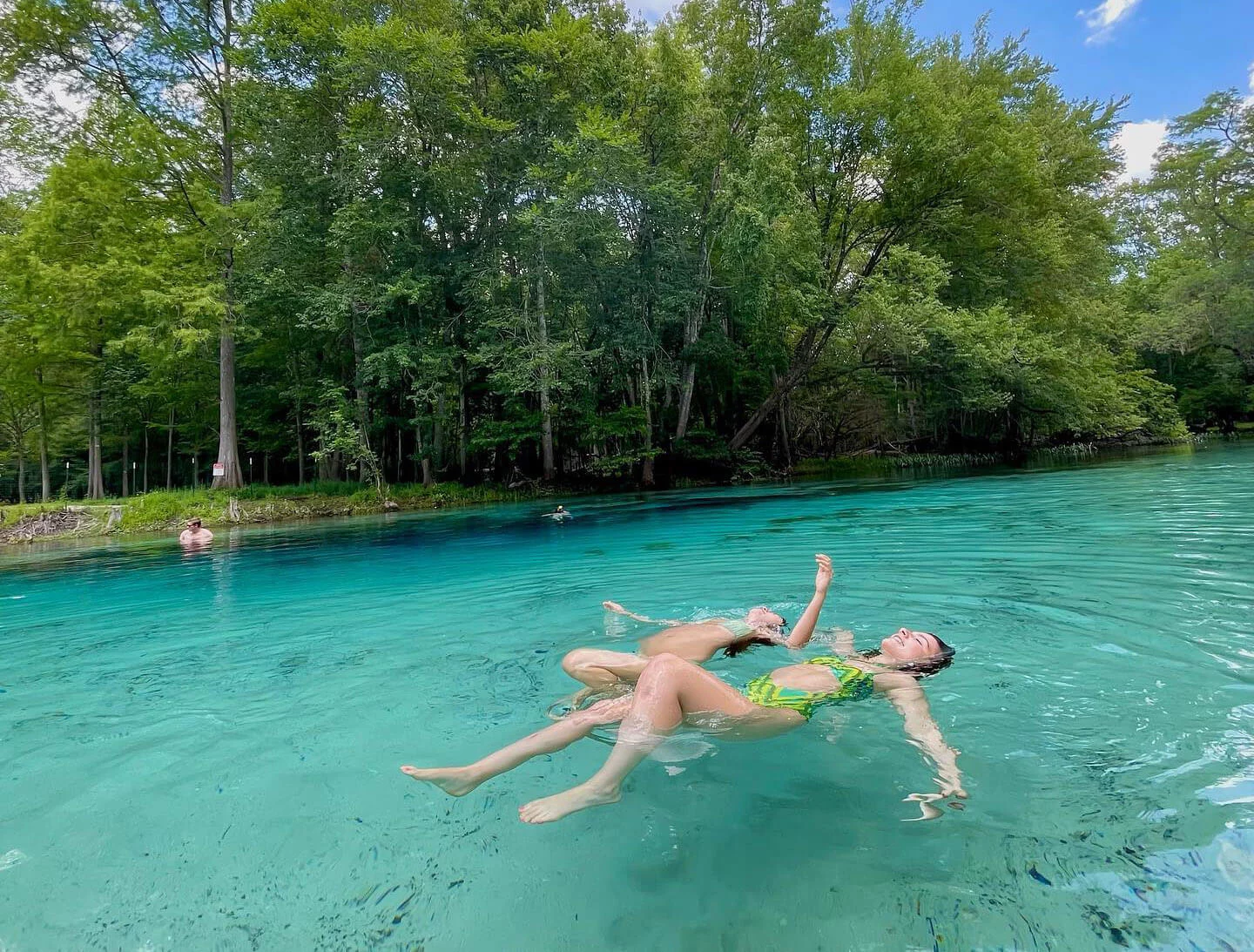 people floating in the water at gilchrist blue springs